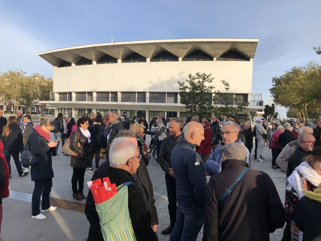 Une foule de personnes se tient devant le Palais des Congrès à Lorient.
