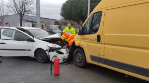 Une voiture blanche cabossée dans une camionnette de La Poste