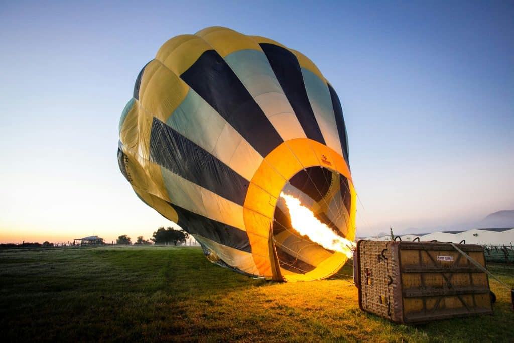 Une montgolfière au sol en train d'être gonflée.